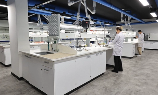 Yiğitoğlu'nun gelişmiş araştırma ve geliştirme tesislerini gösteren, geniş ve modern bir laboratuvarda çeşitli istasyonlarda çalışan bilim insanları.